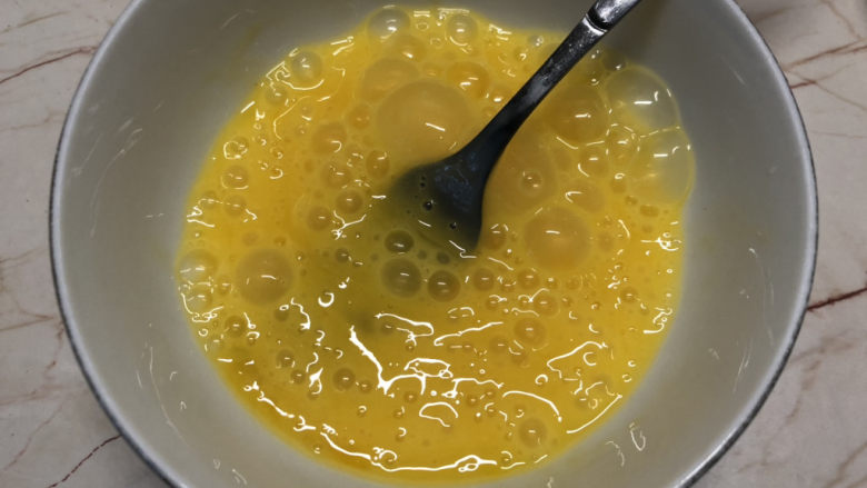 芹菜叶炒鸡蛋,将鸡蛋打散,尽量挑高一点,打入更多空气