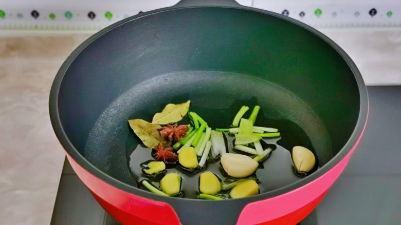 鹌鹑蛋烧排骨,起油锅,加入葱姜蒜八角桂皮煸炒出香味。