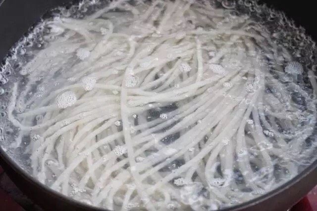 砂锅米线,锅中烧开水,放入泡软的米线煮约2分钟,捞出过凉水备用。