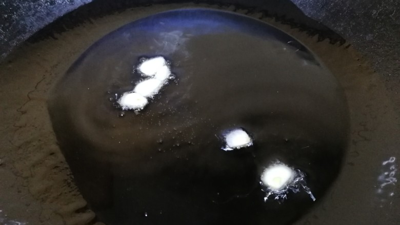 青椒炒杏鲍菇,热锅凉油,放入蒜片,文火炒出蒜香味。