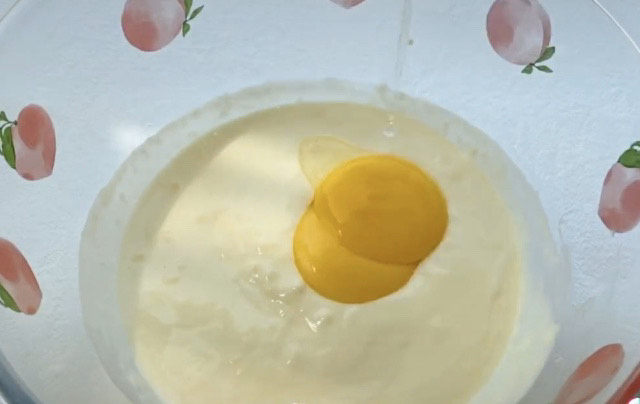 半熟芝士蛋糕,准备的两个<a style='color:red;display:inline-block;' href='/shicai/ 9'>鸡蛋</a>,提前分离出蛋黄和蛋白,两个蛋黄加入,混合均匀