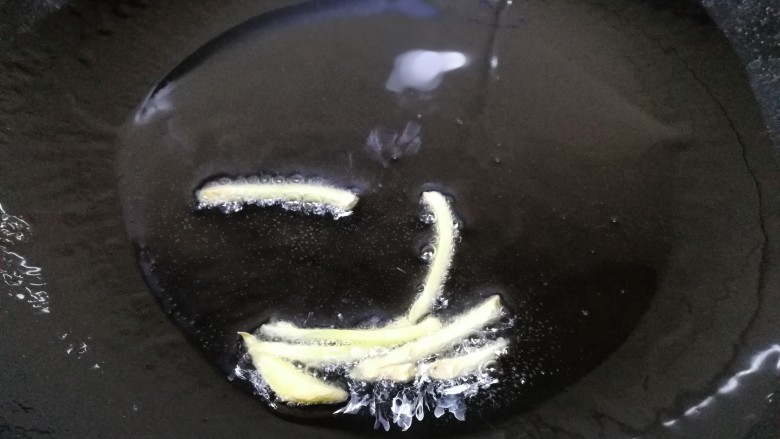 雪菜炒肉丝,热锅凉油,油热放入姜丝文火炒香。
