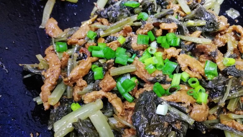 雪菜炒肉丝,放入葱花,文火炒匀。