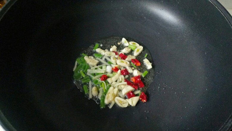青椒炒杏鲍菇,炒锅中加入适量花生油烧热,放入葱、姜、蒜、干辣椒爆香