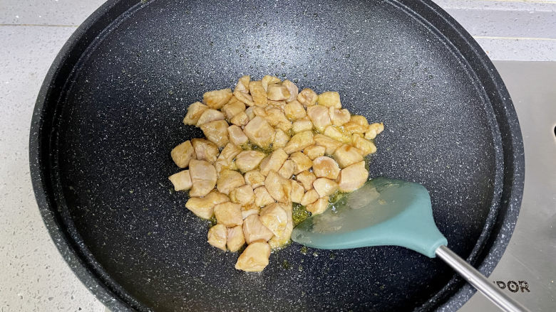黄瓜炒鸡丁,荤素搭配,清新爽口,锅里热油,下入腌好的鸡肉丁炒至变白。