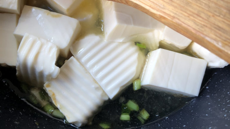 葱油豆腐,轻轻翻动豆腐炒均匀,倒入开水。