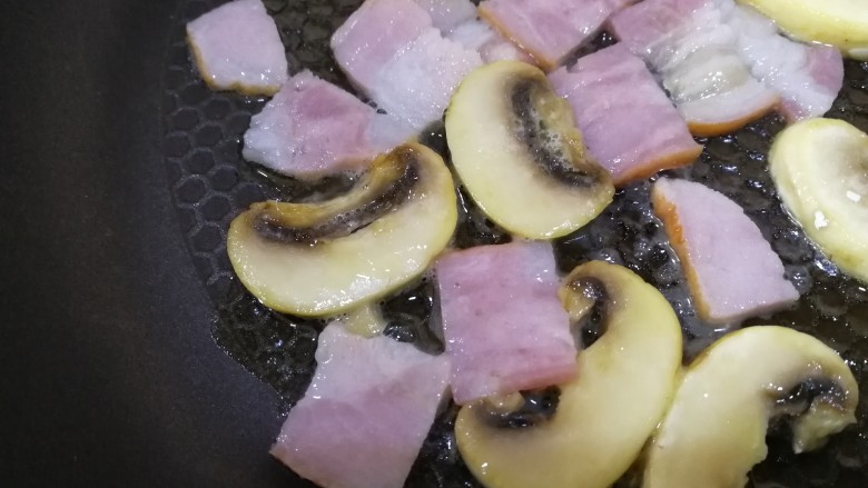 吐司培根披萨,口蘑煎面煎好,放入切碎的培根,用锅里剩余的黄油中小火煎香。
