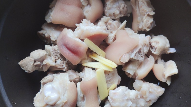 黄豆猪脚汤,洗干净的猪脚放进铸铁锅,并加入剩余的姜片,没有铸铁锅可以用砂锅
