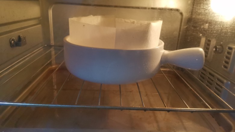 半熟芝士蛋糕,送入预热好的烤箱,用水浴法烘烤,蛋糕放烤网上中层,烤盘里加入水放底层,上下火140度烤50分钟,再转170度烤10分钟上色