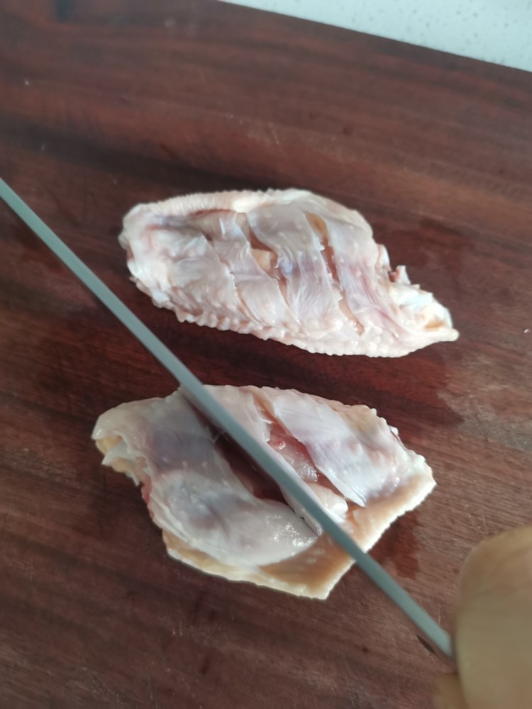 电饼铛蒜香烤翅,捞出控水,用刀切几下方便入味