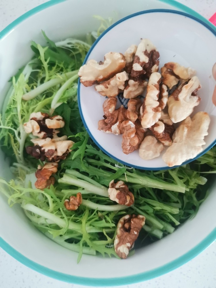 核桃仁拌苦菊,控干水后放入大碗中,加入核桃仁