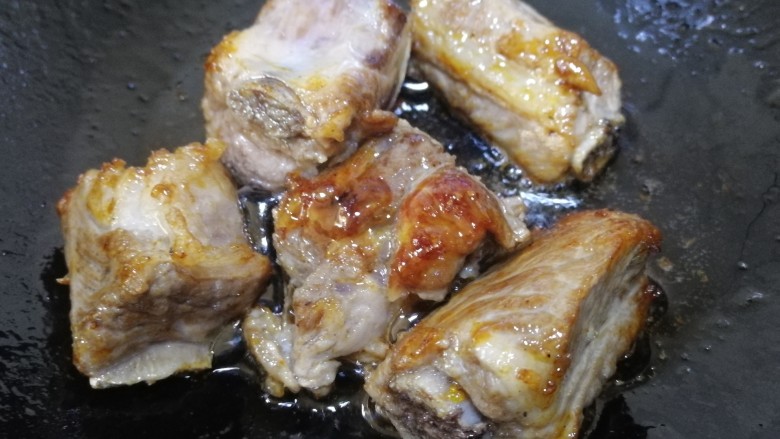 鹌鹑蛋烧排骨,放入排骨,文火翻炒上色。