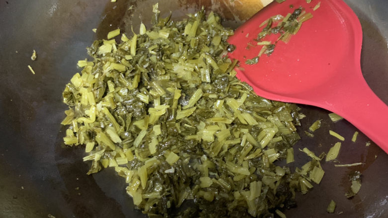 雪菜炒肉丝,炒至雪菜出香味儿调小火,加一圈水继续翻炒