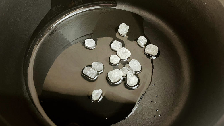 鹌鹑蛋烧排骨,锅中倒入适量的食用油烧热,放入<a style='color:red;display:inline-block;' href='/shicai/ 866'>冰糖</a>炒至变成焦黄色