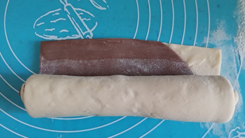 可可双色馒头卷,白色面团在外面,从上往下卷起来,最后边缘抹水,卷起来捏紧