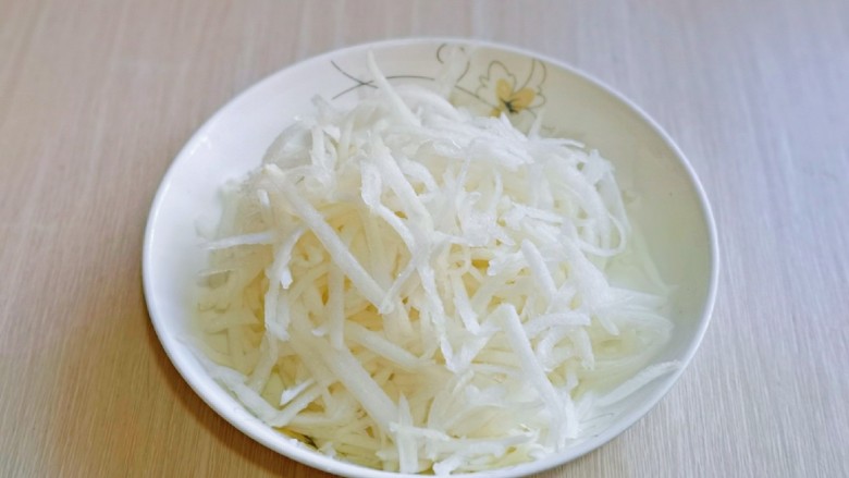 凉拌海蜇头,<a style='color:red;display:inline-block;' href='/shicai/ 24'>萝卜</a>去皮,洗干净,插丝工具插丝,撒上1盐,抓拌均匀,腌制15分钟。