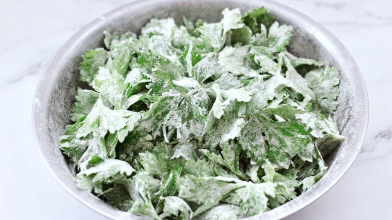 粉蒸芹菜叶,把芹菜叶和面粉搅拌均匀,芹菜叶片片都沾满面粉就可以了。