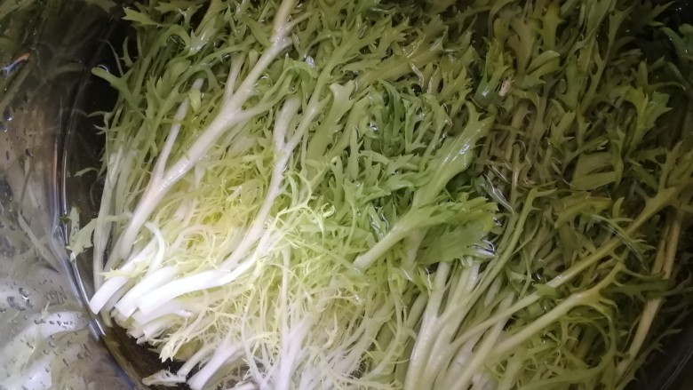 凉拌苦菊,切去根部,放入小苏打的清水里,泡3分钟,清水冲洗干净。