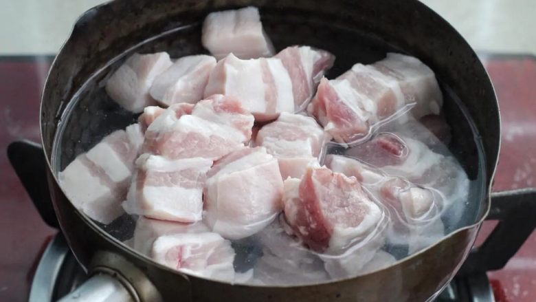 梅干菜烧肉,将切好的肉块直接冷水下锅,大火煮至沸腾后用勺子撇去表面浮沫。