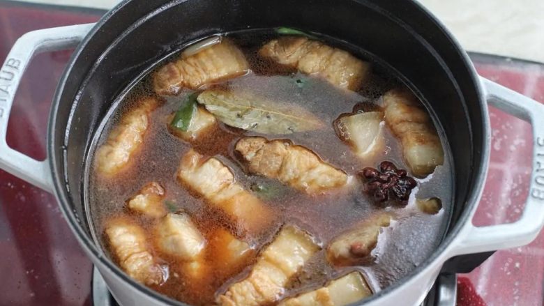 梅干菜烧肉,倒入提前烧好的热水没过五花肉,盖上锅盖大火烧至沸腾后改小火炖煮40-50分钟。