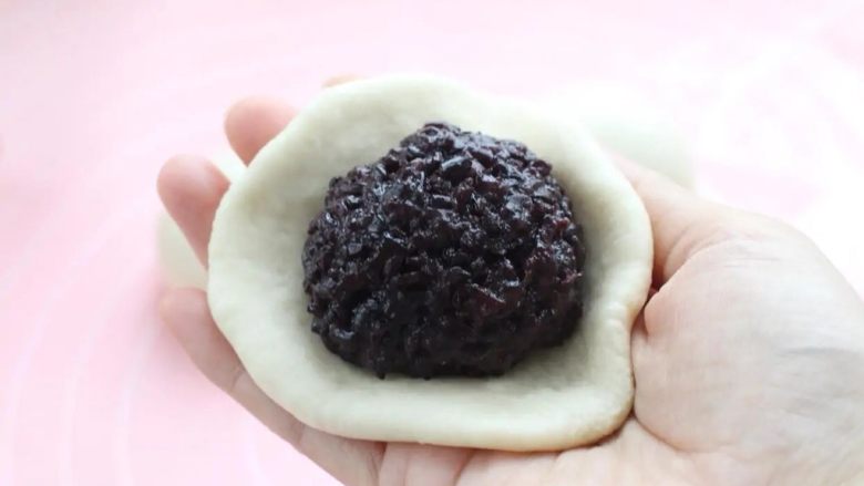紫米面包,取面团按扁擀成饼皮,在中间放紫米馅。