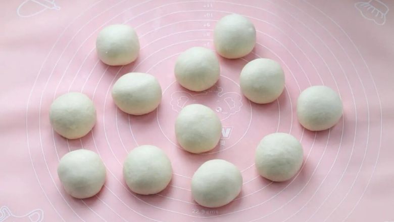 紫米面包,取出面团按压排气,分成均匀的12个小面团,滚圆覆盖保鲜膜松弛20分钟。