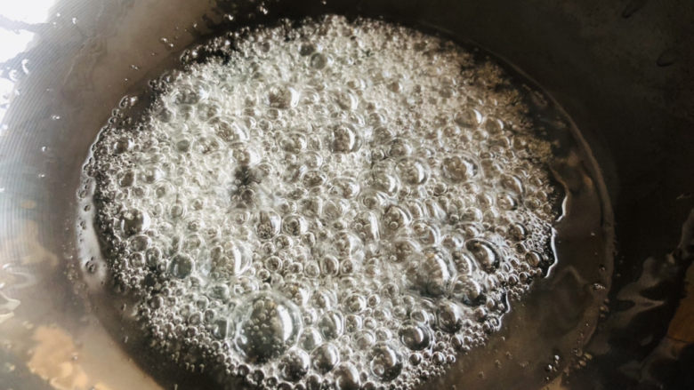 山楂球,中小火把糖水烧开,烧至冰糖慢慢融化且开始变得黏稠时一边搅拌一边中火慢慢烧,待水分完全蒸发后,继续煮至糖水开始冒绵密小泡即可关火。