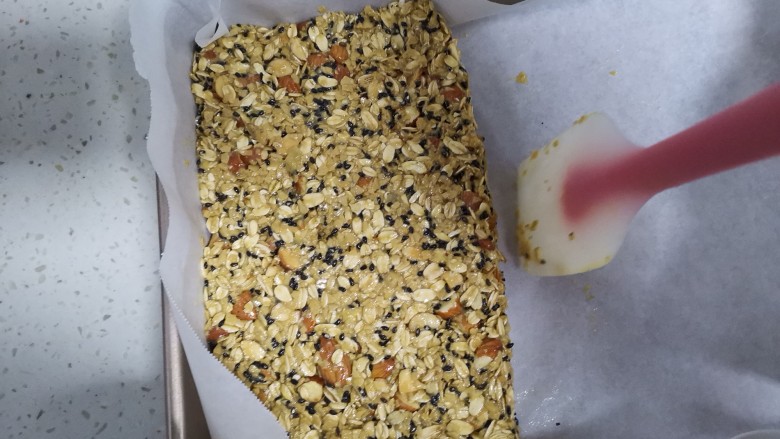 燕麦棒,倒入铺好油纸的烤盘里,整理成长方形