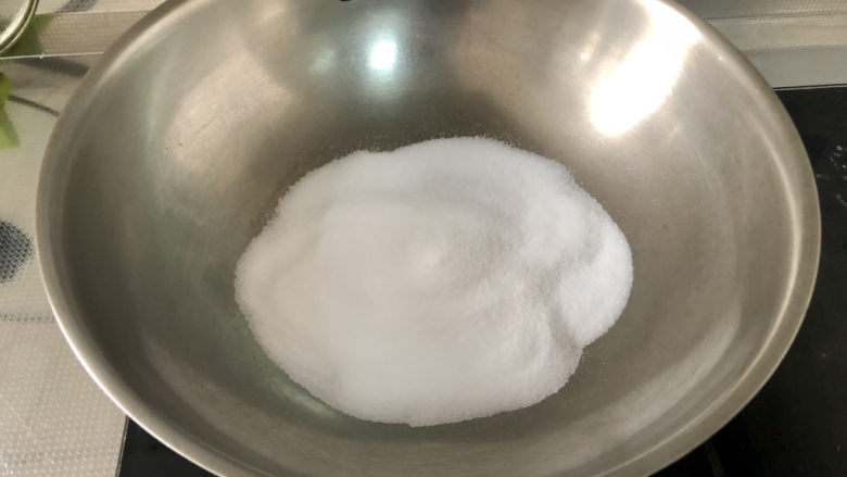 盐焗花生米,锅中放入食盐,开火,小火把盐炒热