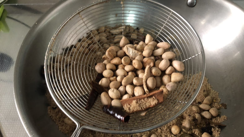 盐焗花生米,用漏勺漏干净食盐,只余花生米和香料,不喜欢香料可以捡出,装盘即可
