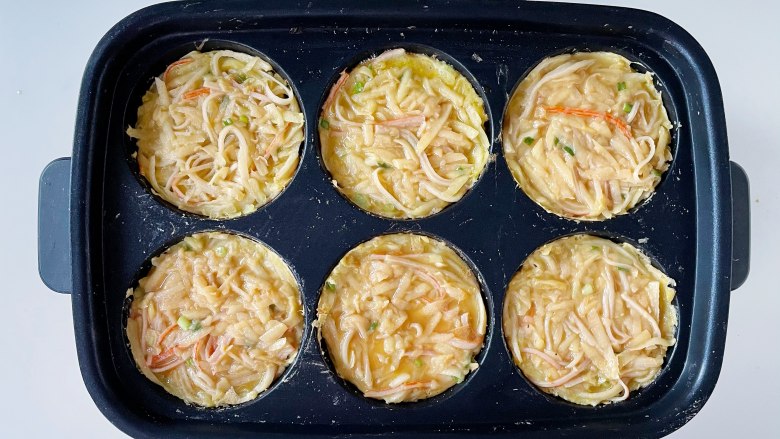 土豆蟹柳鸡蛋饼,把拌好的的食材填入圆盘用中火煎制。