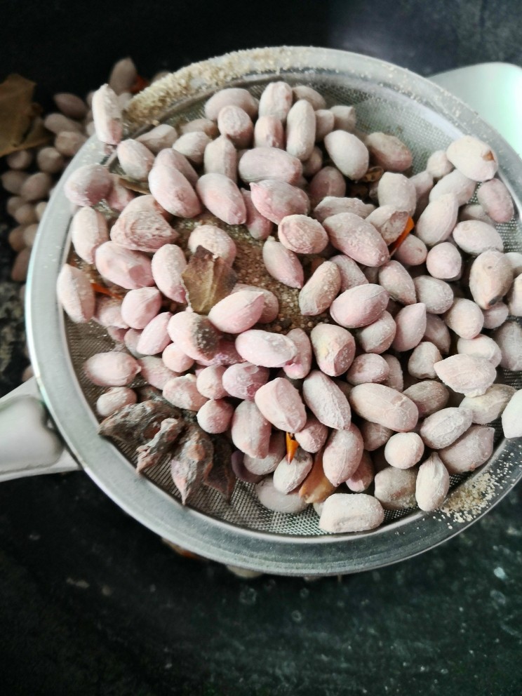 盐焗花生米,用筛子筛去食盐,<a style='color:red;display:inline-block;' href='/shicai/ 4262'>花生米</a>放在盘子晾凉就可以食用了。