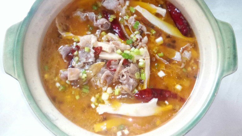 酸菜肥牛,盛入汤煲中,撒葱花。