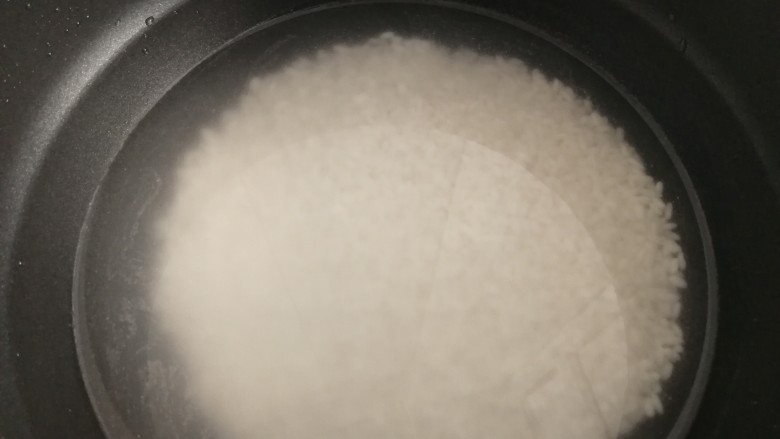 排骨糯米饭,泡好的糯米放入锅里,加适量水。