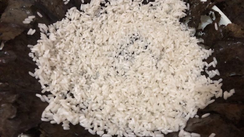 排骨糯米饭,把泡好的荷叶洗洗放入一个微深碟里,倒入一半糯米