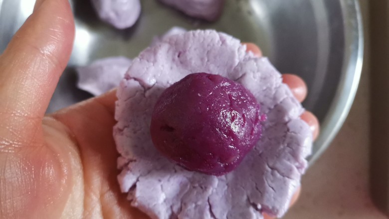 紫薯糯米糍,取一个糯米面团剂子按压成饼状,包入紫薯馅,像包汤圆一样,收口捏紧