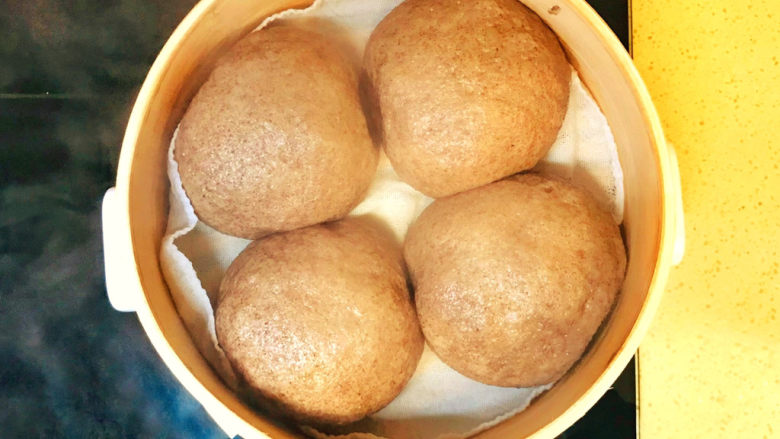 黑米馒头,二次发酵到位后,打开火,高火烧开后,继续高火蒸十五分钟,就可以关火了,继续焖三分钟,就可以掀开锅盖了