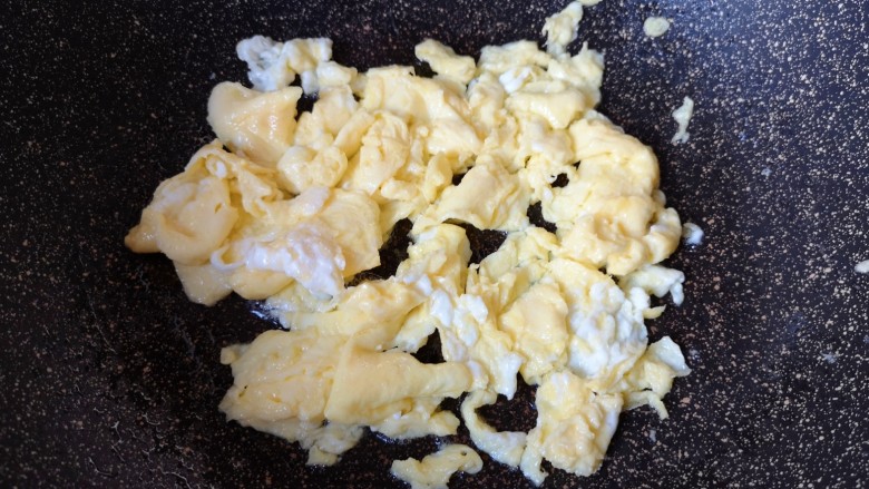 鸡蛋炒年糕,炒锅内放适量的食用油烧热,倒入蛋液快速炒熟,盛出备用。