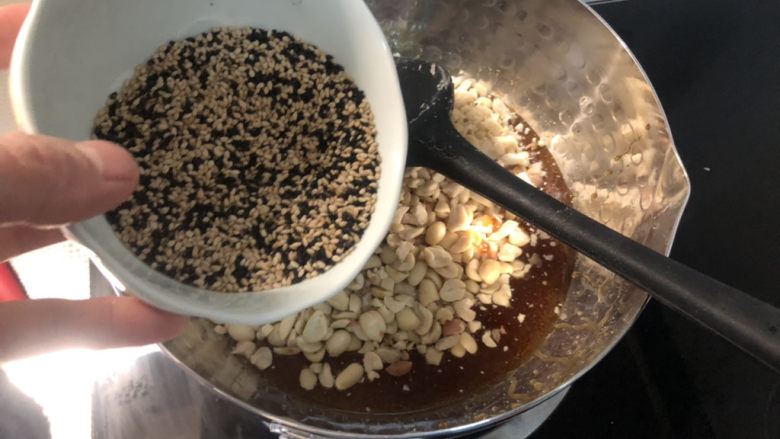 芝麻花生糖,倒入芝麻,快速翻炒均匀