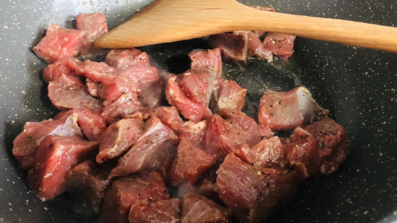 简单美味的杏鲍菇牛肉粒,锅里放油,下入牛肉粒划至变色。