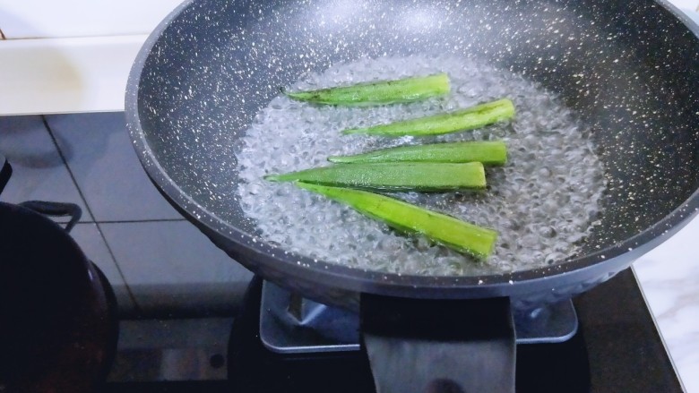 尖椒牛柳,秋葵,冷水冲洗干净,去根,水烧开后放入秋葵,焯水1分钟,捞出。