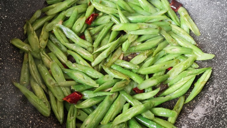 清炒四季豆,加入半碗水焖炒6-8分钟,豆角炒至9成熟。