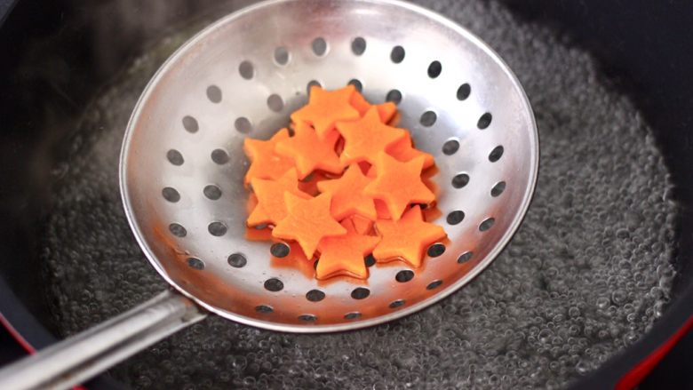 山药泥圣诞树,锅中倒入适量清水,加少许盐和几滴食用油煮沸,放入胡萝卜焯熟捞出备用。