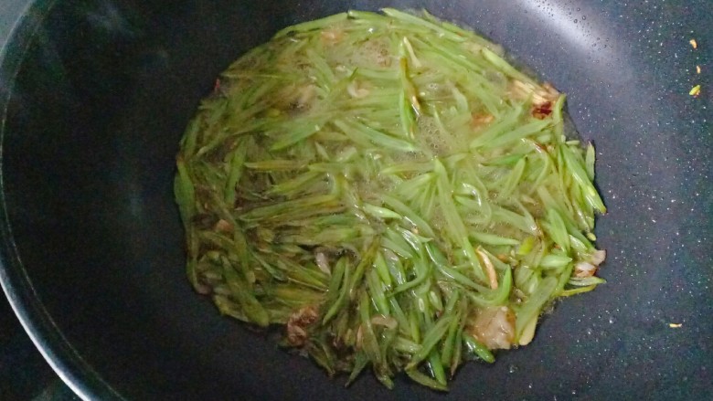 清炒四季豆,加入与四季豆平齐的水,盖上锅盖焖煮至四季豆熟透