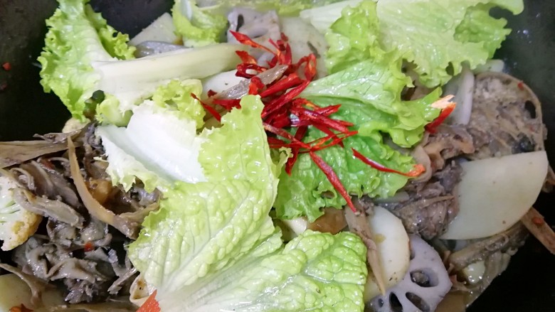 干锅鸭头,下入<a style='color:red;display:inline-block;' href='/shicai/ 92833'>生菜叶</a>和辣椒包里的的红辣椒翻炒均匀出锅(辣椒也根据自己的口味放,我没有放完)。