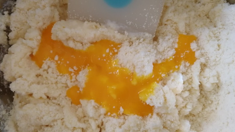 蓝莓果仁司康,加牛奶和半个蛋黄液,用硅胶铲切拌。