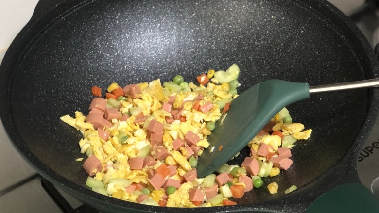 花环炒饭,下入解冻好的什锦蔬菜里翻炒;