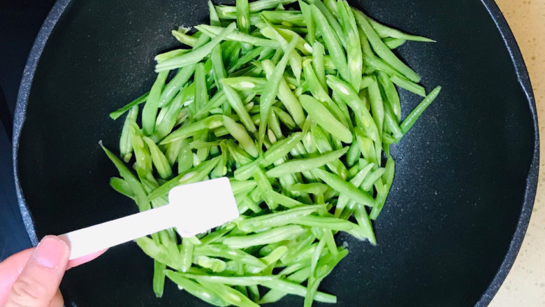 清炒四季豆,翻炒至变色后,撒入盐调味