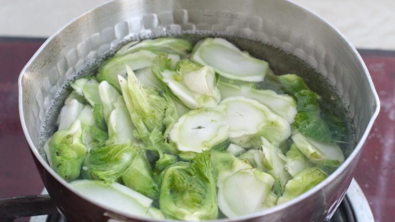 清炒儿菜,锅中烧开水,先下入儿菜的茎焯烫三十秒,再下入叶子烫三十秒,捞出过凉水沥干水分。