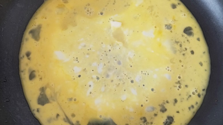 黑糯米蛋,锅中加适量油,倒入鸡蛋液小火加热煎制,至鸡蛋呈金黄色,用锅铲将鸡蛋弄碎盛到盘子中备用